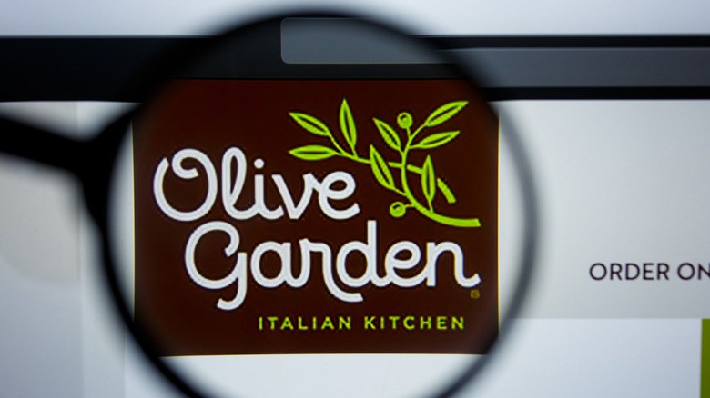 A magnifying glass held up to an Olive Garden logo on the website