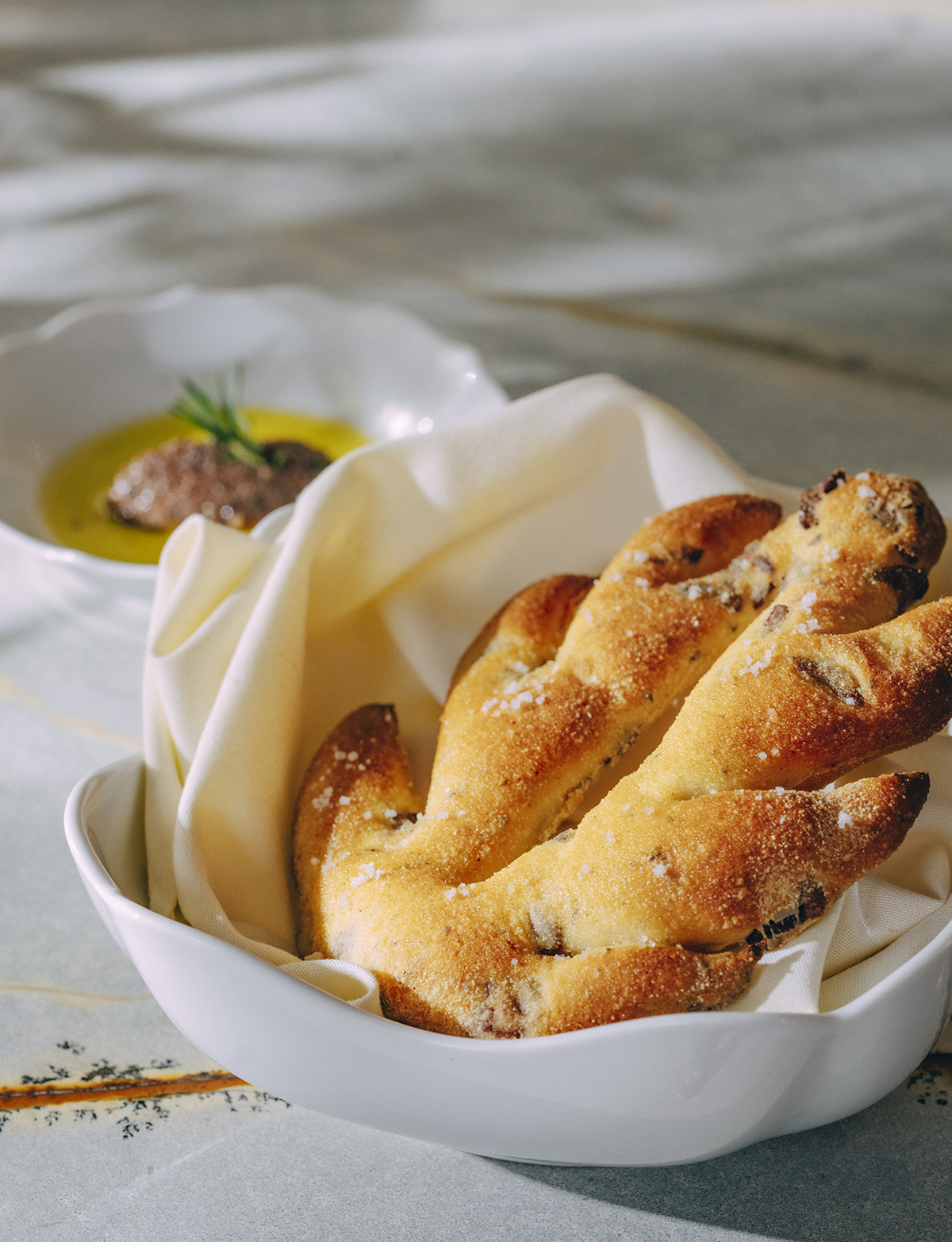 Sourdough rosemary fouglasse, a bread dish served with olive oil...