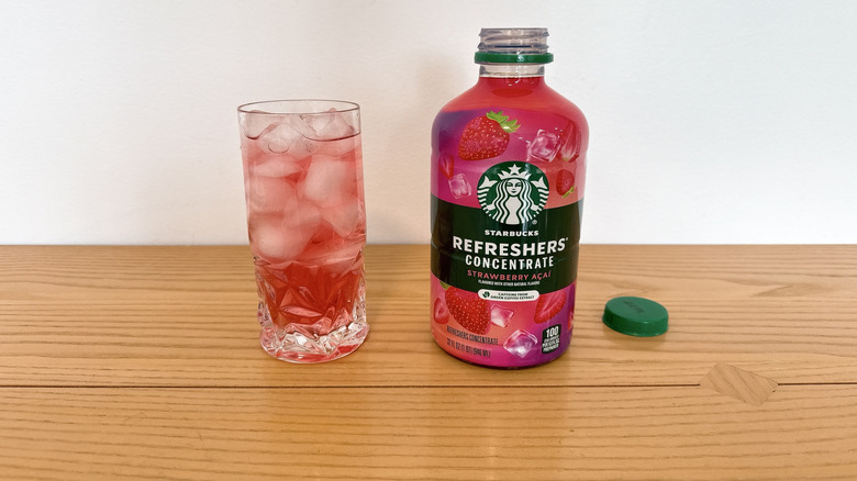 Starbucks Strawberry Acai Refreshers Concentrate bottle and poured into a glass