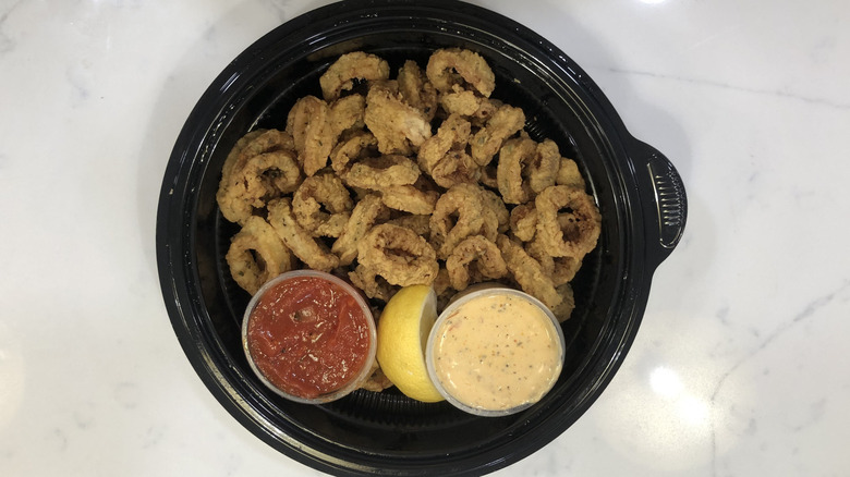 Overhead view of Olive Garden fried calamari appetizer and dipping sauces in a plastic container