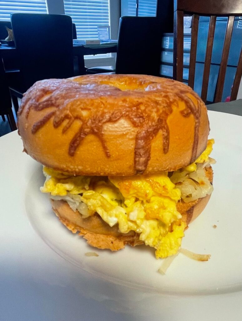 Leftover IHOP (eggs, hashbrowns, chicken-fried steak) in a buttered/toasted Asiago bagel w/provolone cheese