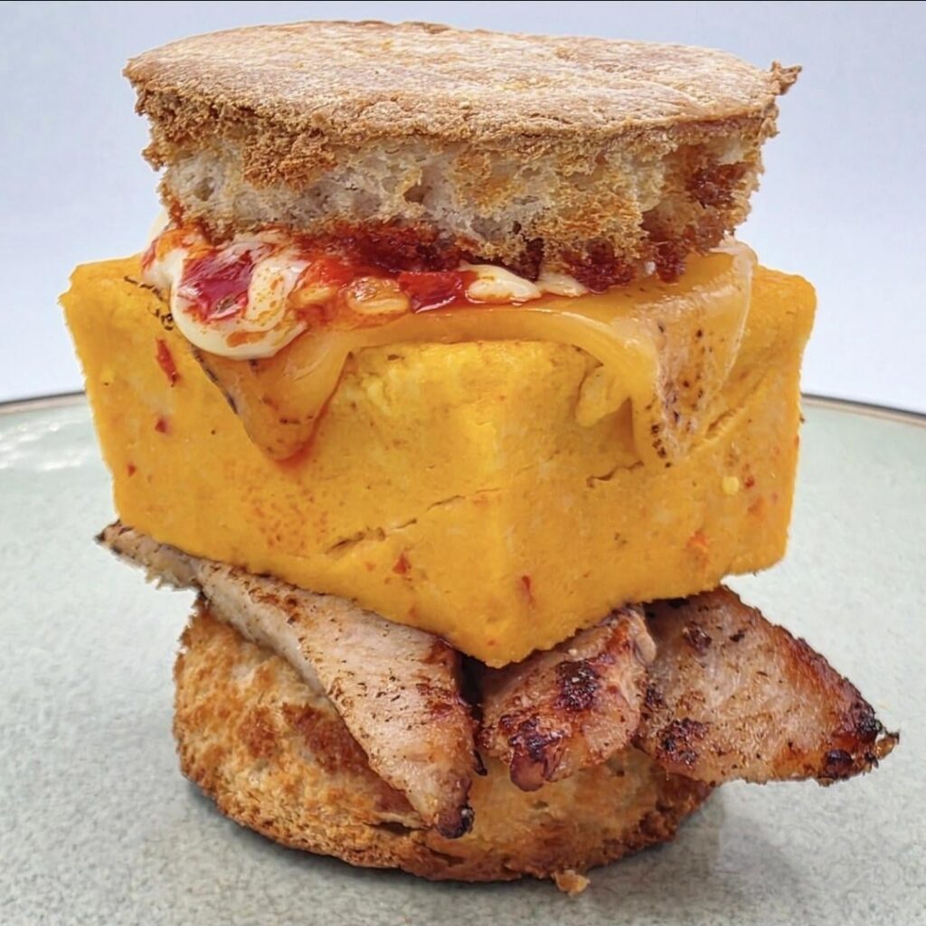 Bricked up, two bite EGG sandwich: pork, Calabrian chili, American cheese, Kewpie mayo