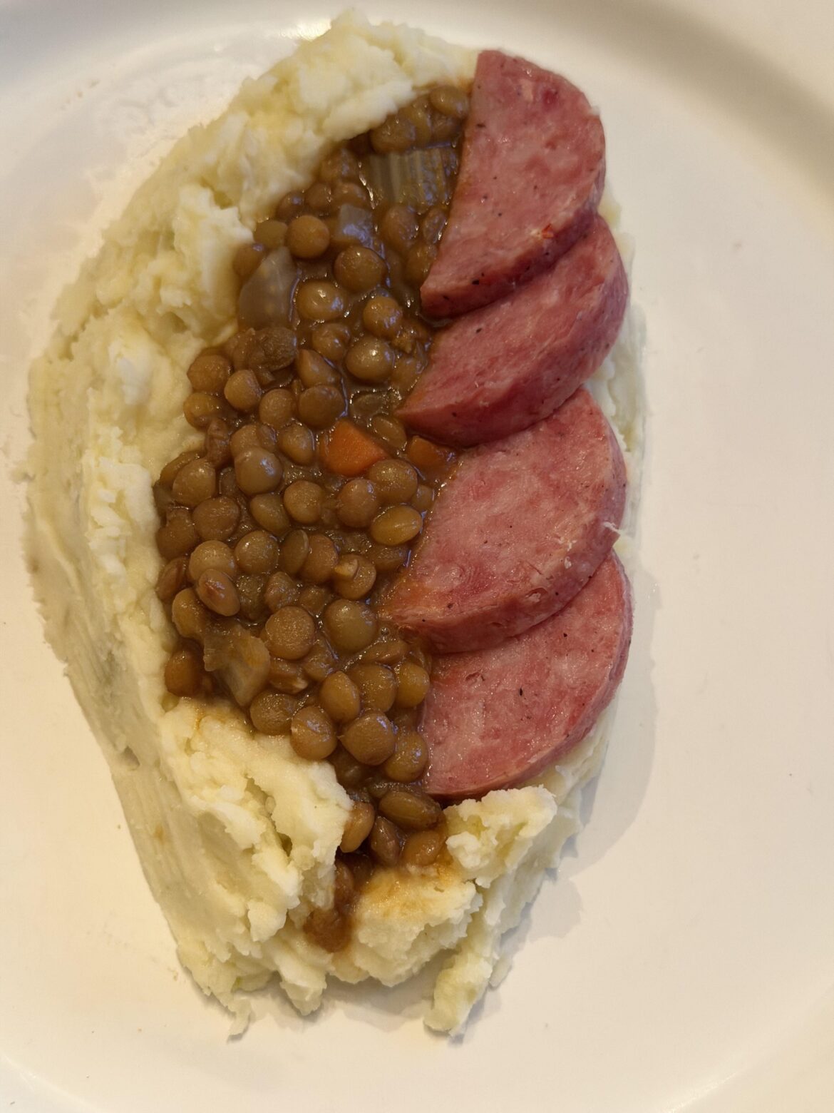 Tuscan cotechino with braised lentils and mashed potatoes.