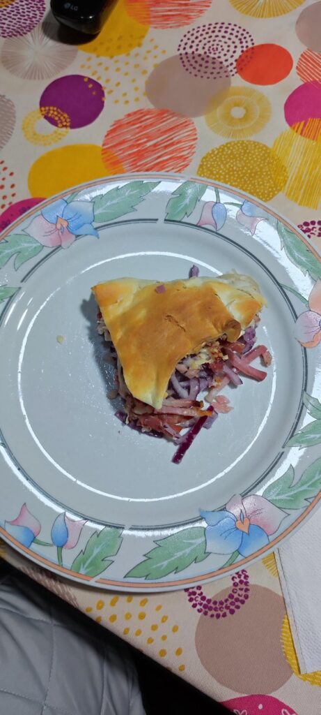 Savory pie with parmesan cheese, red onions and speck