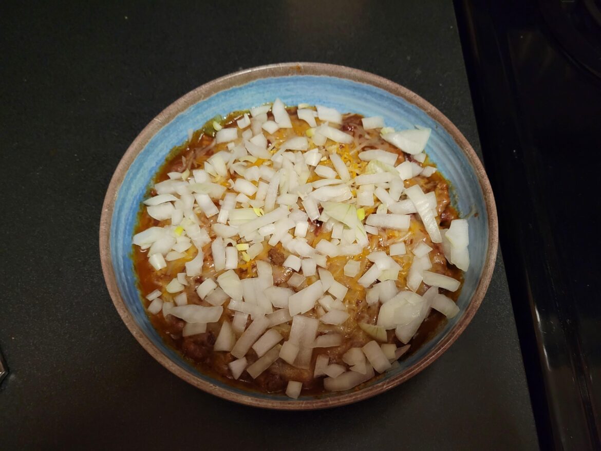 Chili Frito pie with a modest amount of onions.