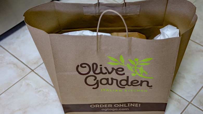 An olive garden to-go bag filled with food