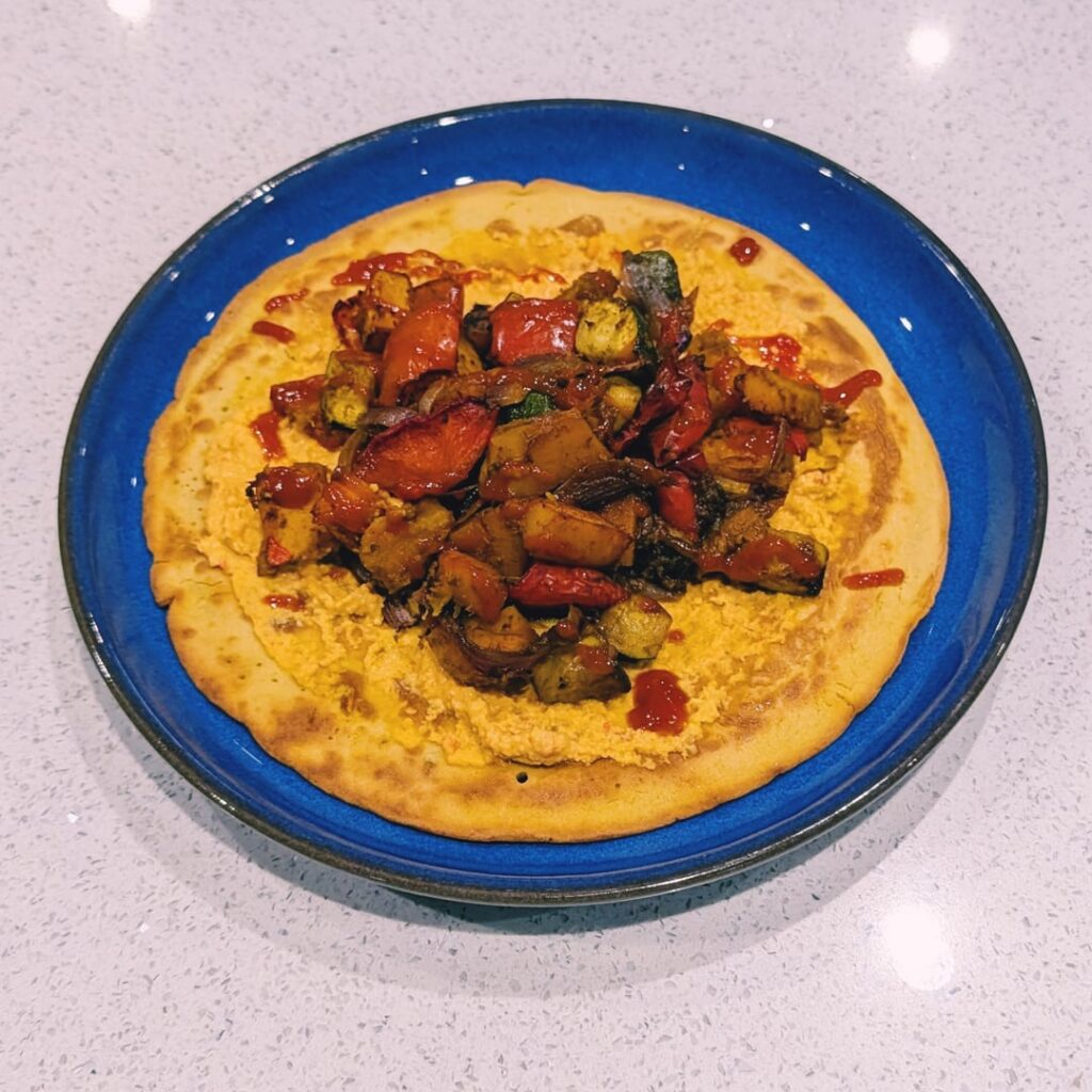 Socca with hummus and toppings Socca with hummus and toppings