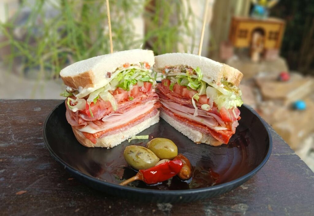 Hot capicola, ham, salami, pepperoni, provolone, olive giardiniera LTM, on sliced Italian loaf with Calabrian peppers on the side (HOT!)