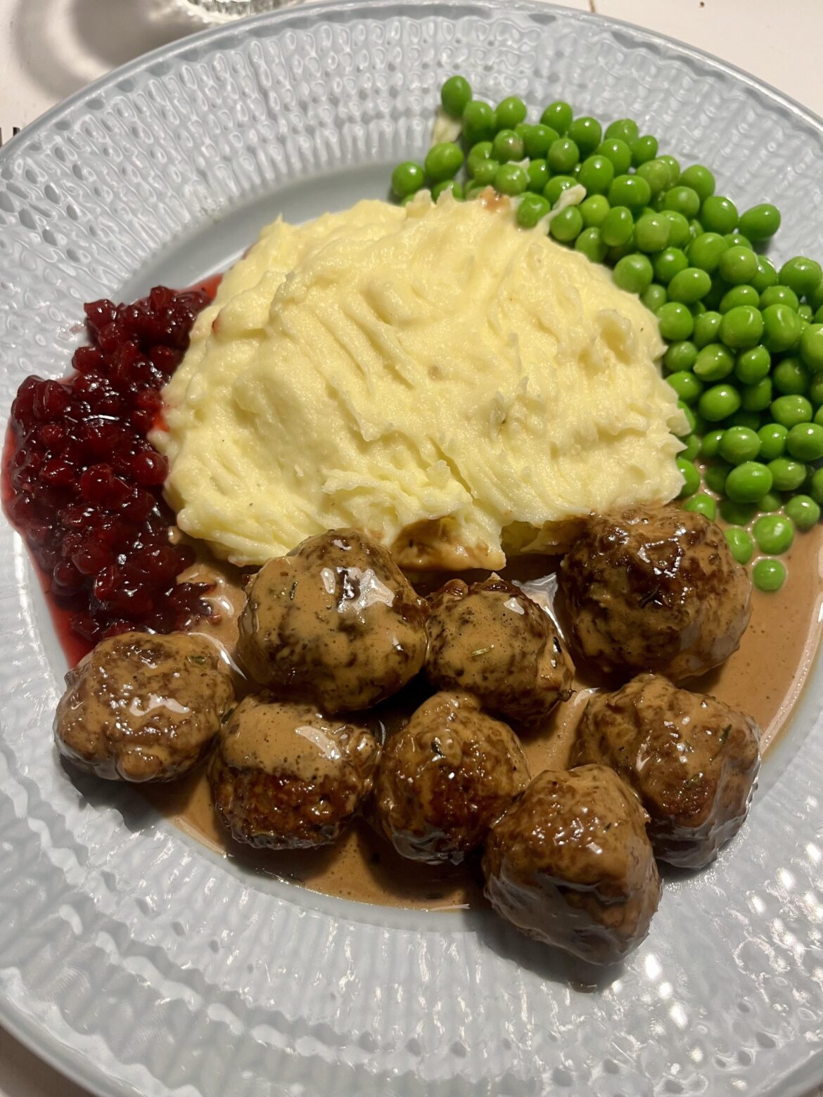 Vegan balls with mashed potato, green peas, gravy and homemade lingonberry jam. Swedish style
