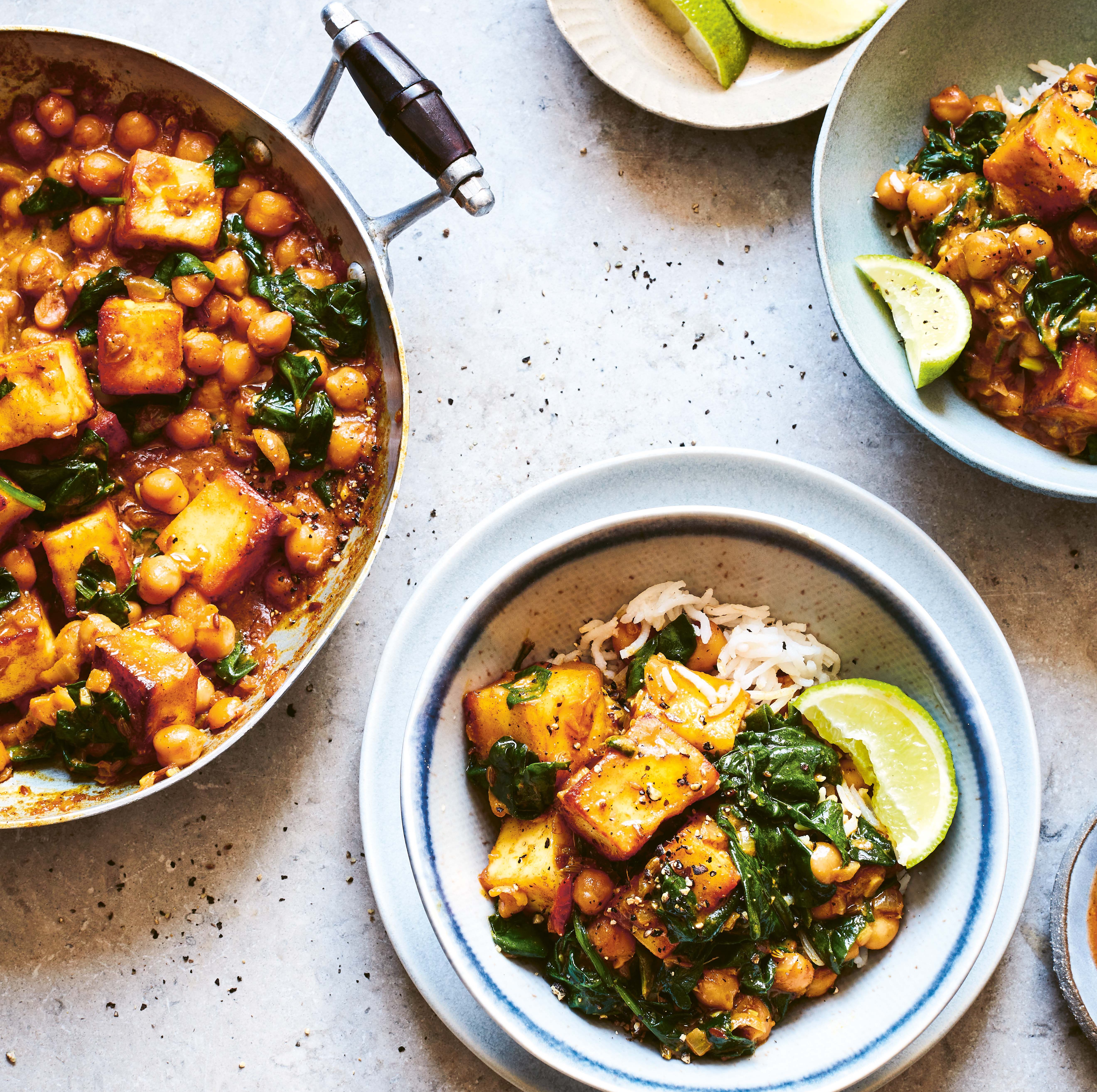 Sag chana paneer with lime wedges.