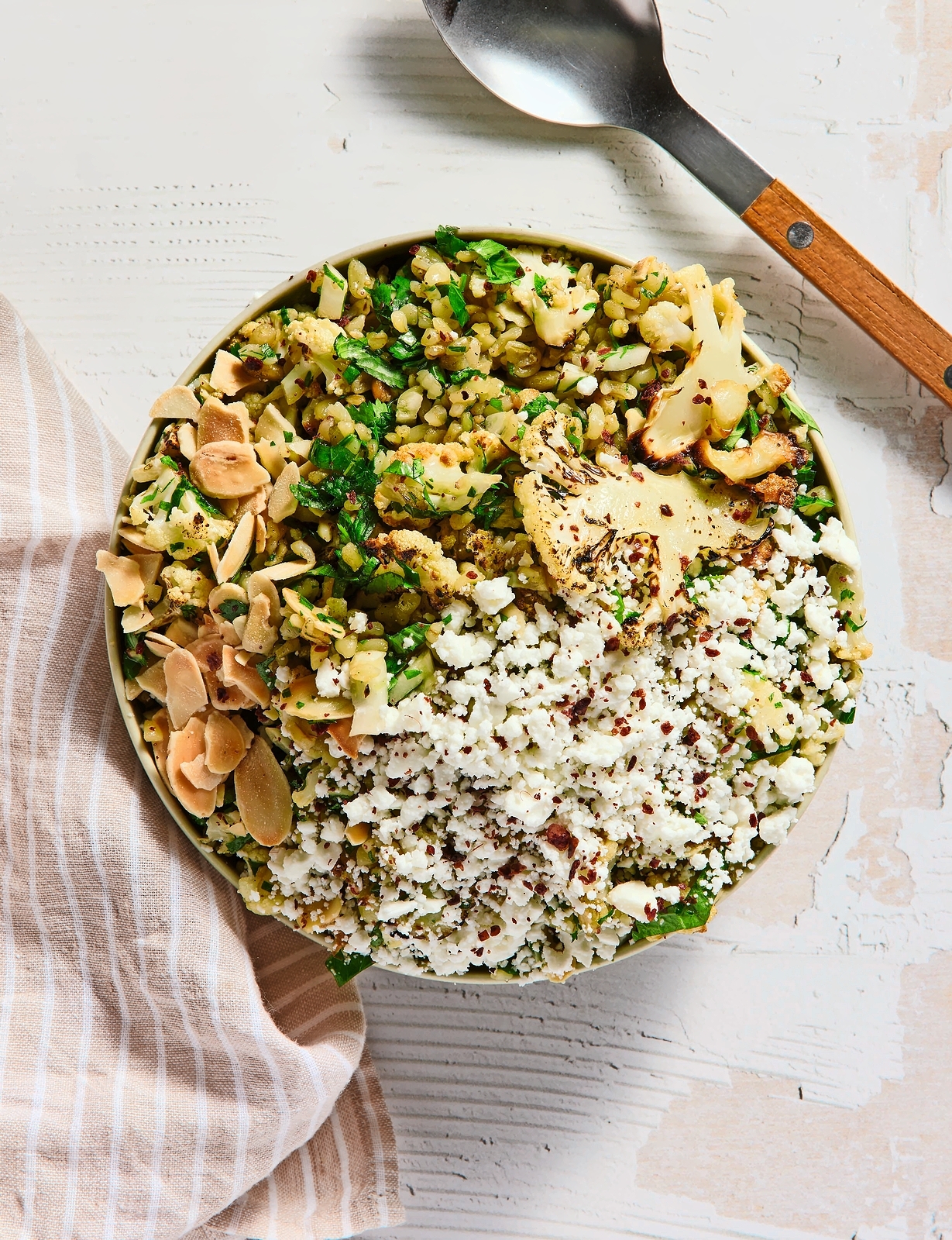 Freekeh tabouleh with roasted cauliflower, crumbled feta, and sliced almonds.