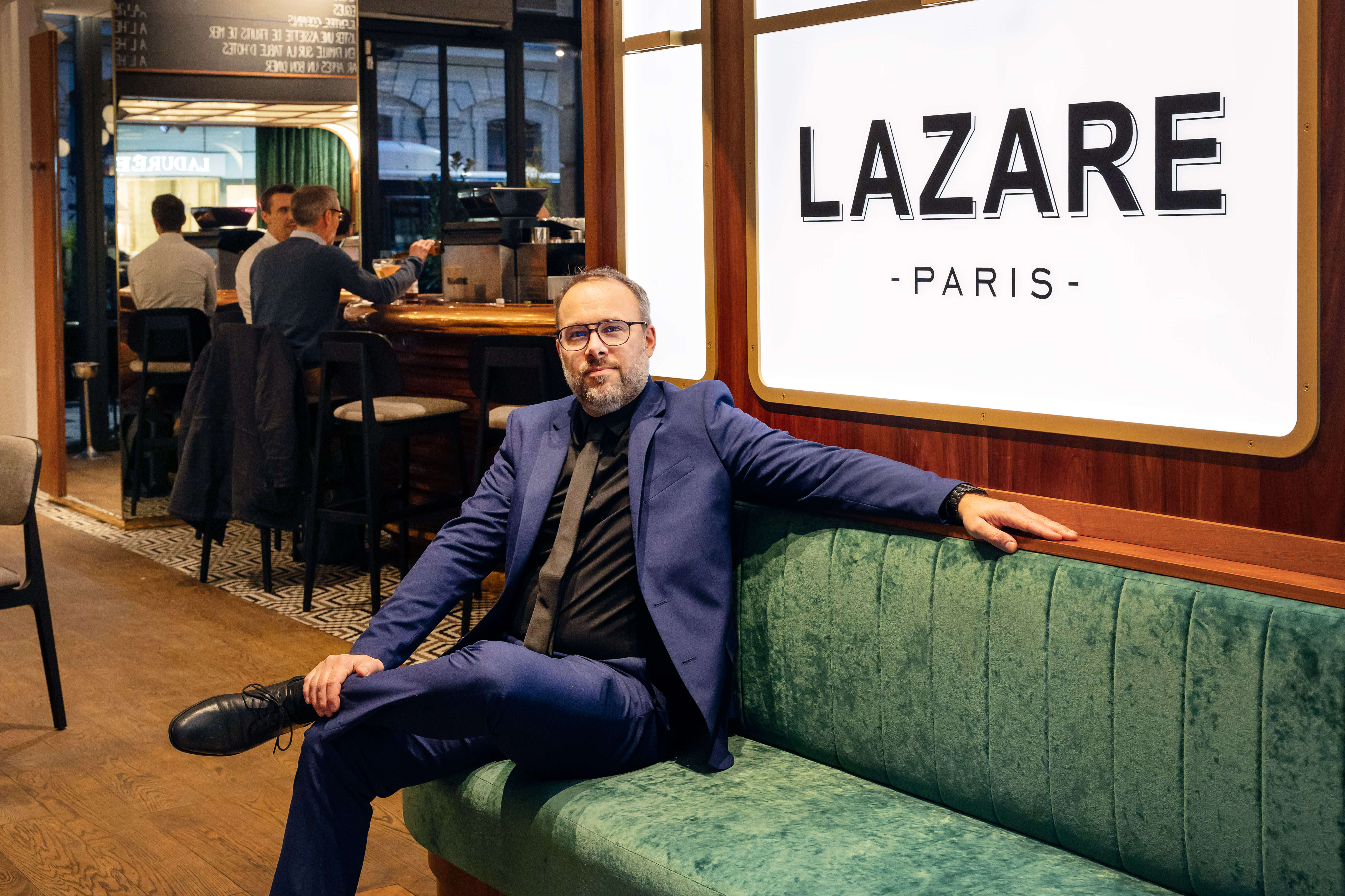 Arnaud Meunier, director of Restaurant Lazare in Paris, sitting on a green bench.