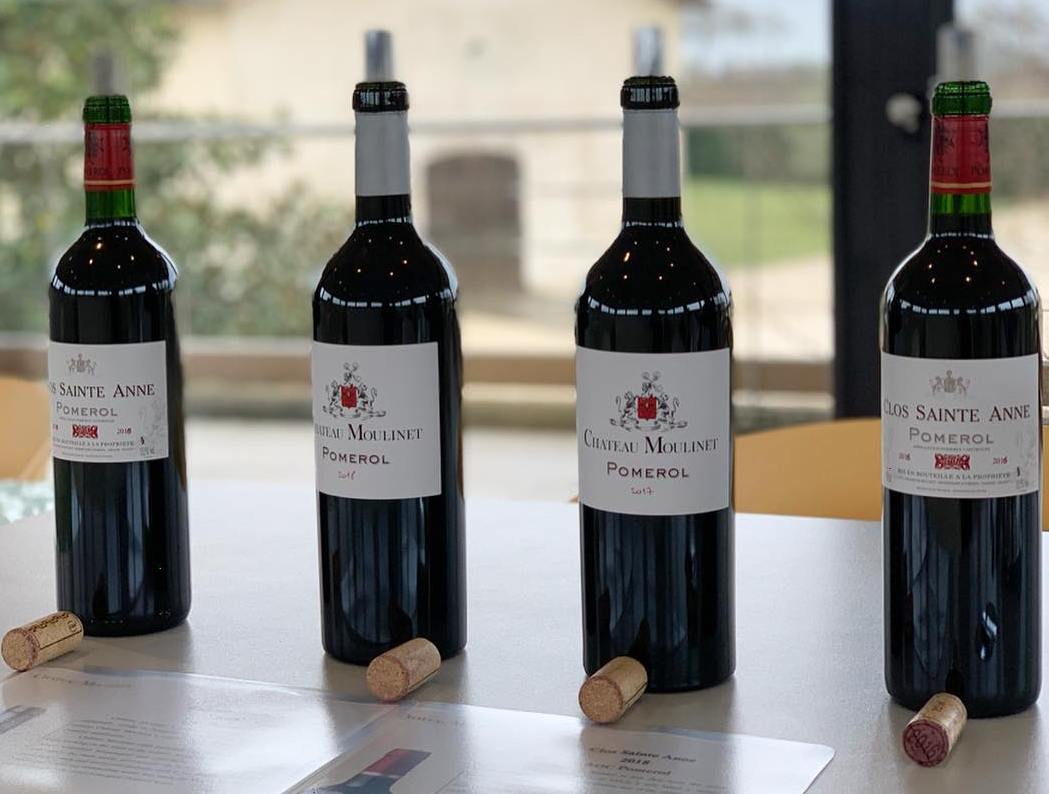 Château Moulinet wine bottles on a table with corks.