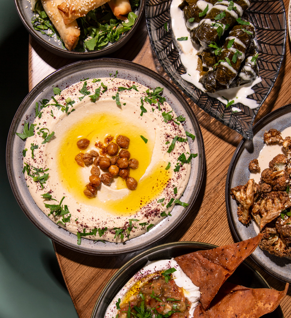 Shared mezze: hummus, cheese cigars, stuffed grape leaves, crispy cauliflower, and smoked eggplant