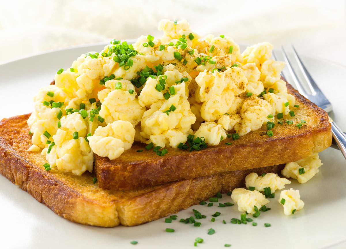 Scrambled egg on toast, with herbs sprinkled on top
