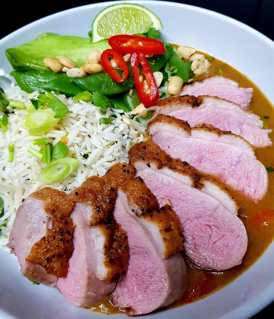 From Scratch Thai Red Curry with Pan Seared Duck. Coconut Lime Rice, Pak Choi and Snap Peas. Finished with Nuts and Herbs.