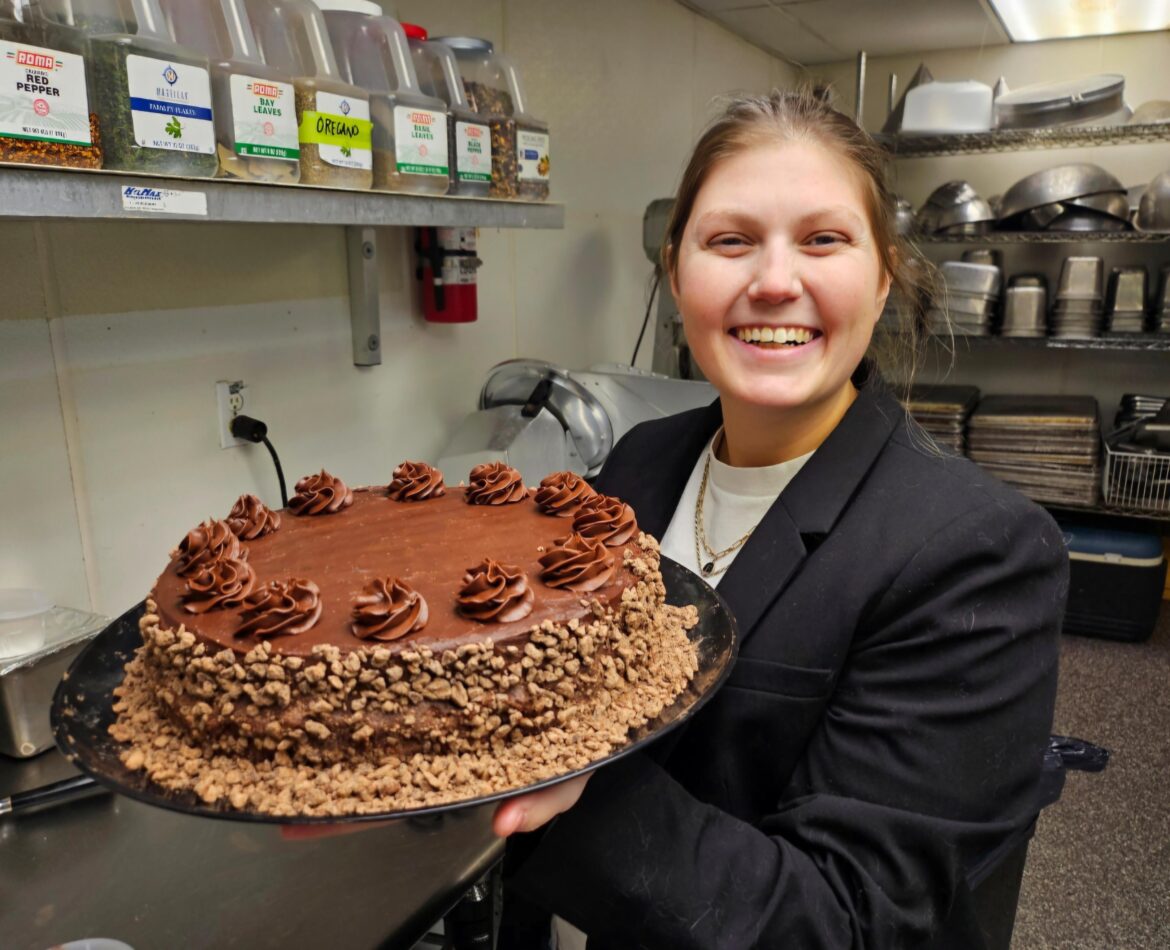 My best friend holding a chocolate cake I made like a proud dad