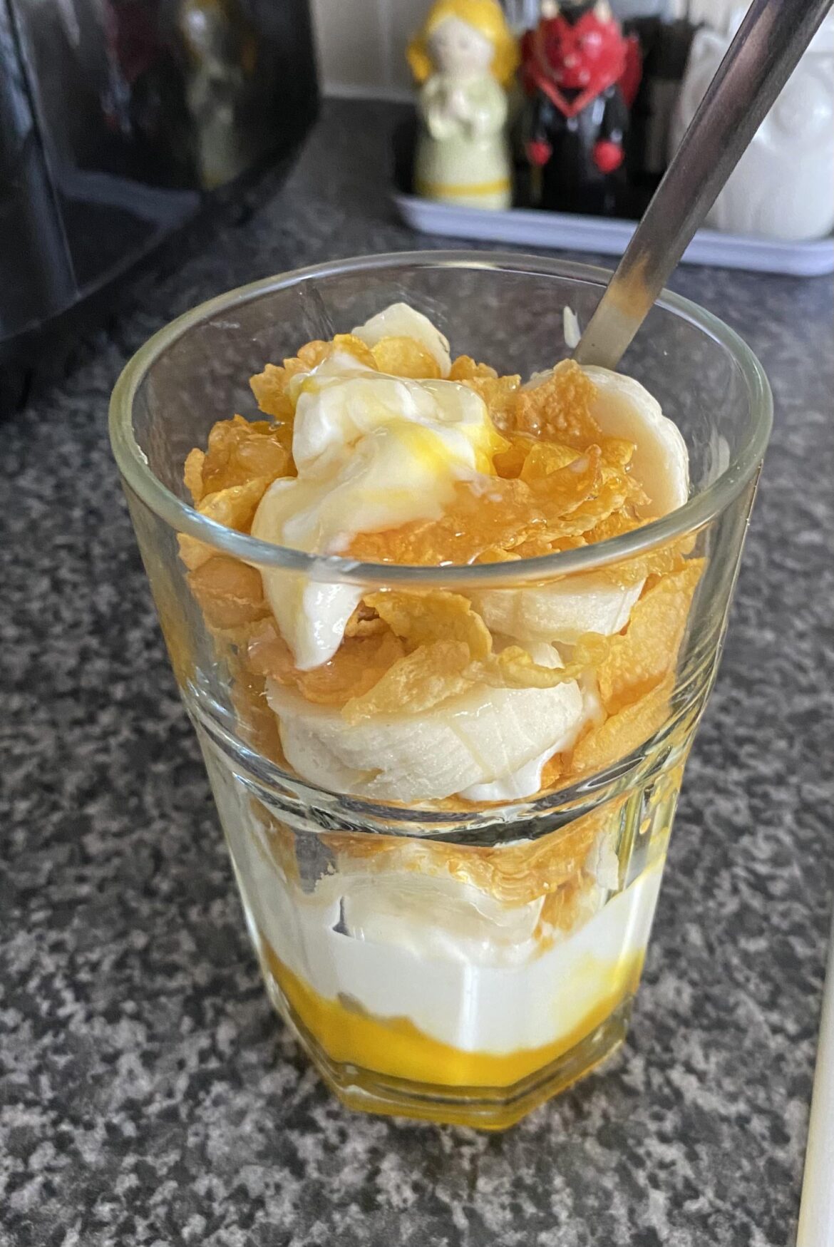 Gourmet Mango Yogurt with banana and cornflakes, drizzled with runny honey
