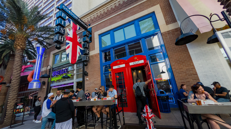 Gordon Ramsay Fish & Chips in Las Vegas storefront with customers eating at tables outside and U.K. themed doors, signage, and fire hydrant