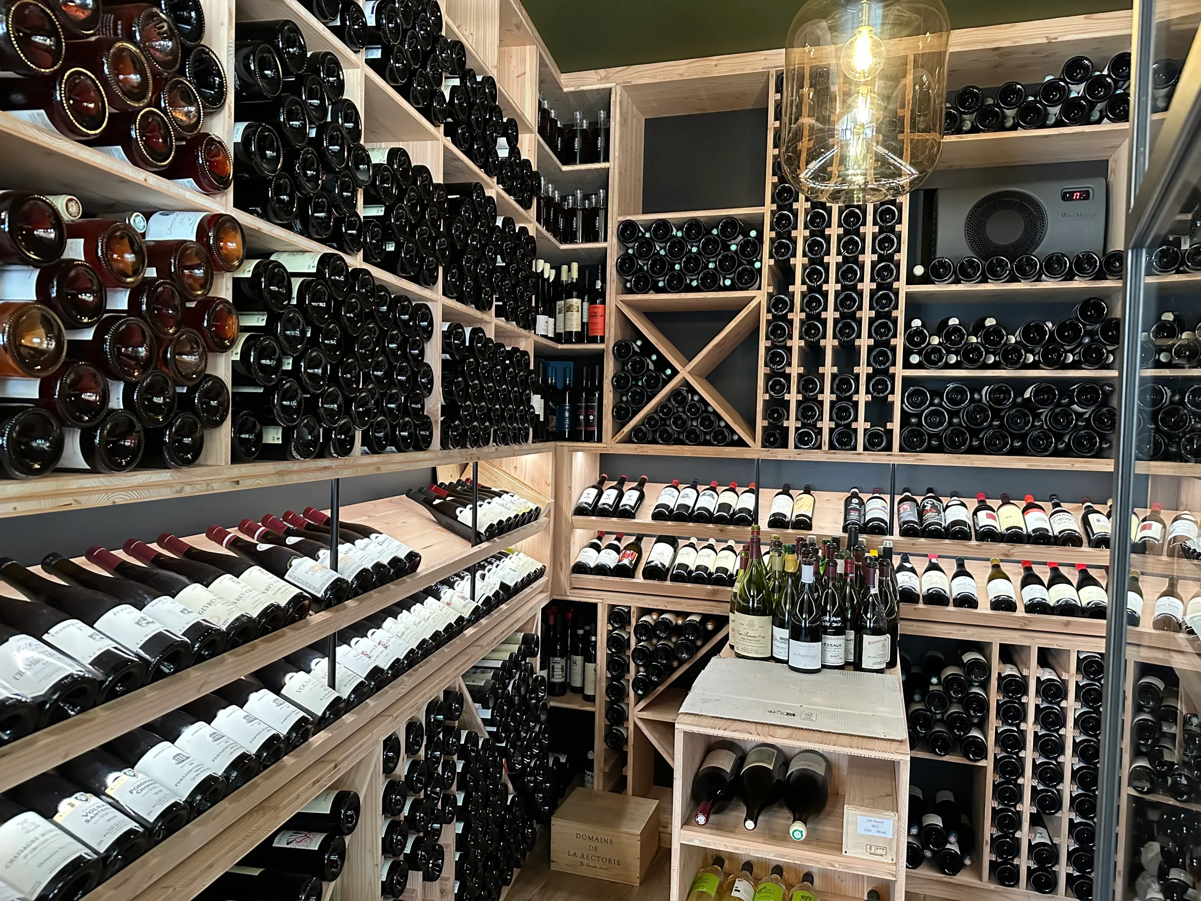 A wine cellar with numerous bottles of wine on wooden shelves.