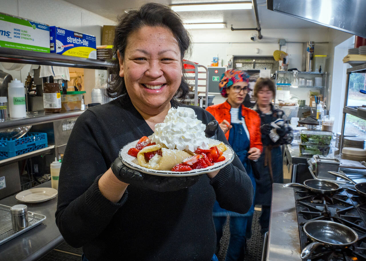 Photo by David Welton. Joan Samson holds up a berries and cream crepe, one of Merriweather Creperies bestsellers.
