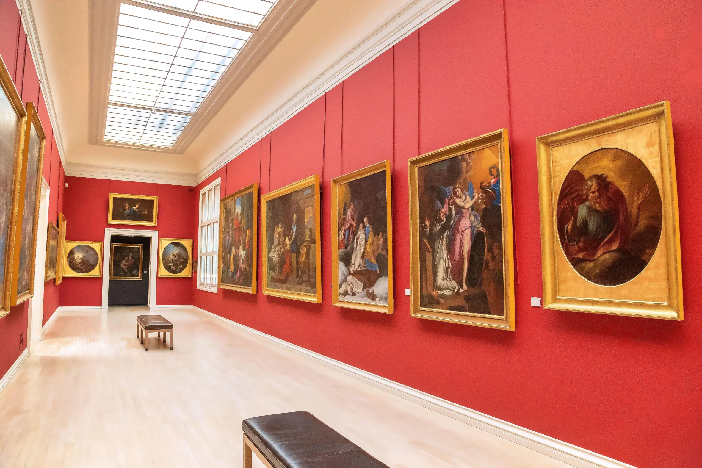 Italian paintings displayed on red walls in the Rouen Museum of Fine Arts.