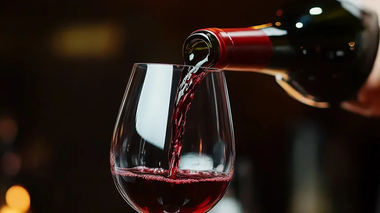 Red wine being poured into a glass.
