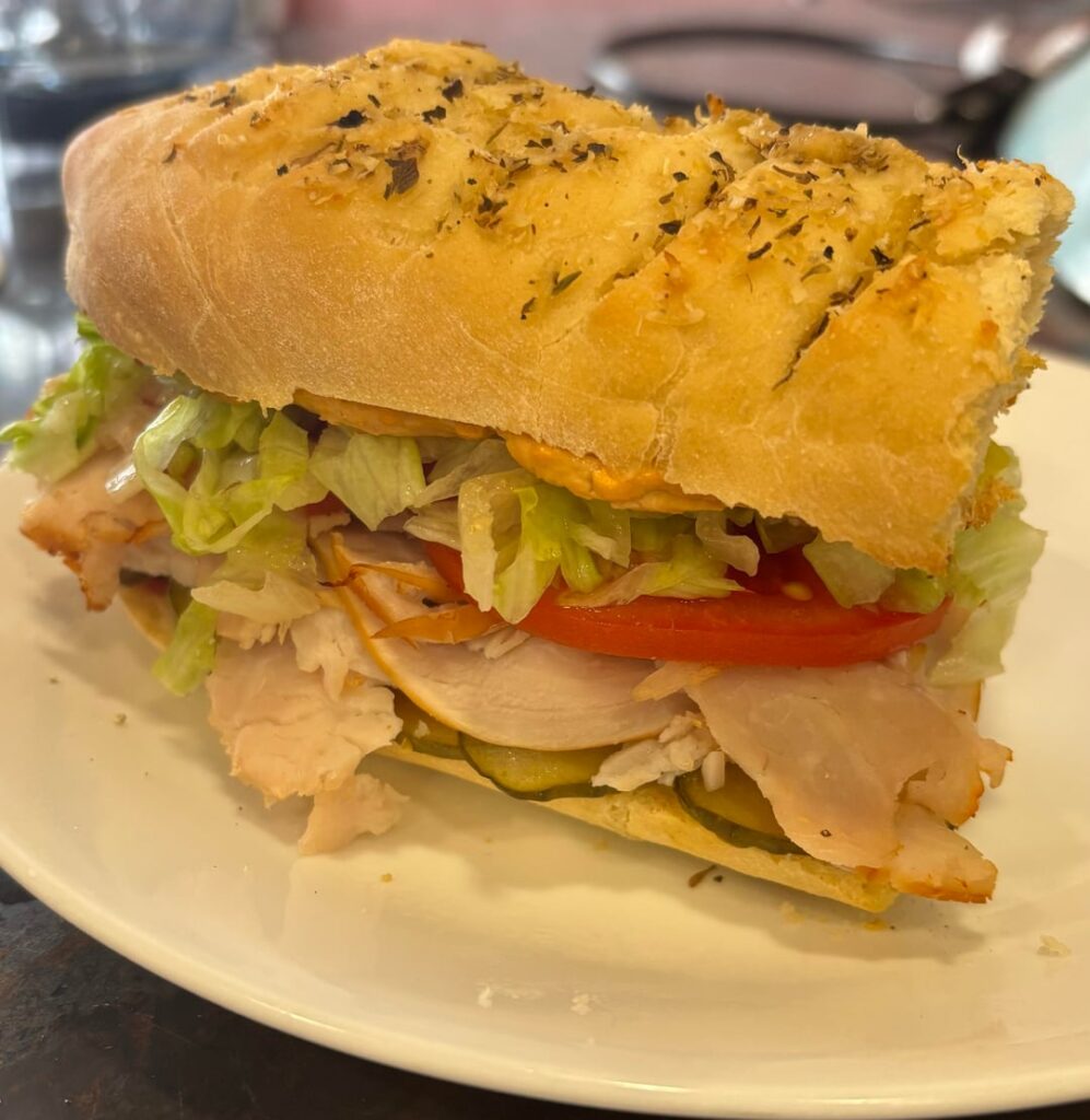 Turkey sandwich on homemade herb and cheese bread with half serving of chips, 383 calories