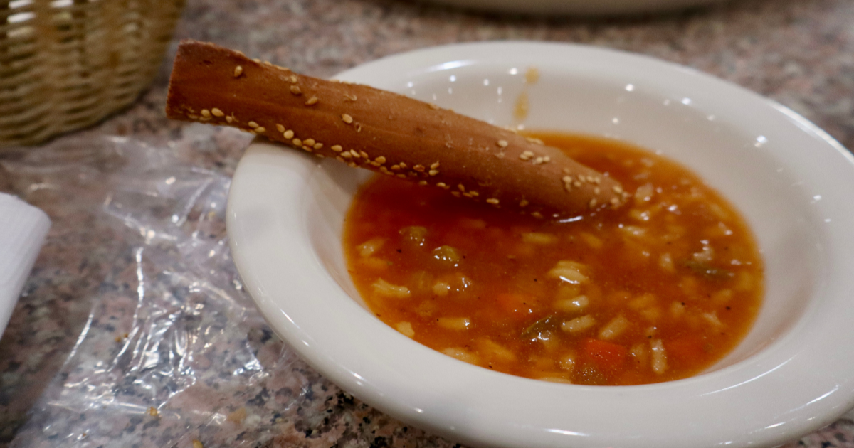A breadstick dipped in a bowl of savory stuffed pepper all you can eat soup Michigan.