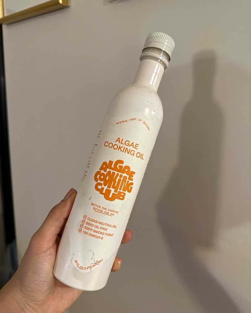 Someone holding bottle of Algae cooking oil.