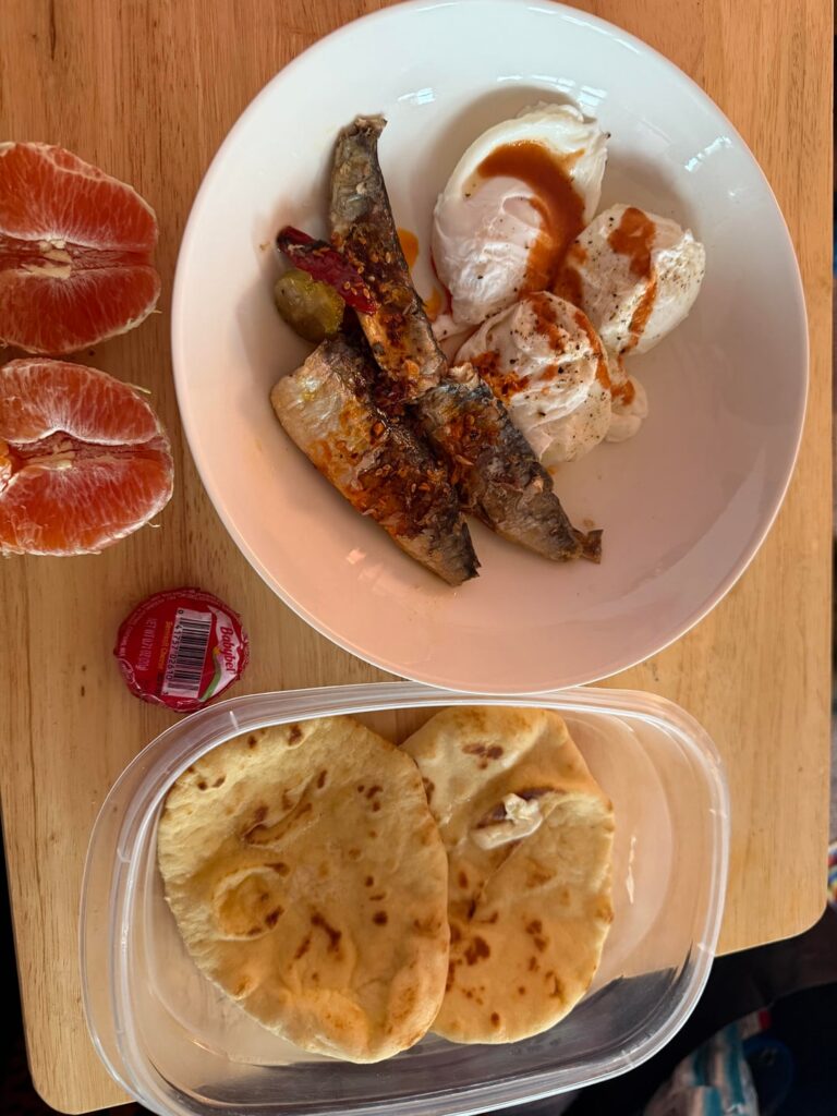 Nuri with chili crisp, poached eggs, naan, Cara Cara orange, and a baby bel