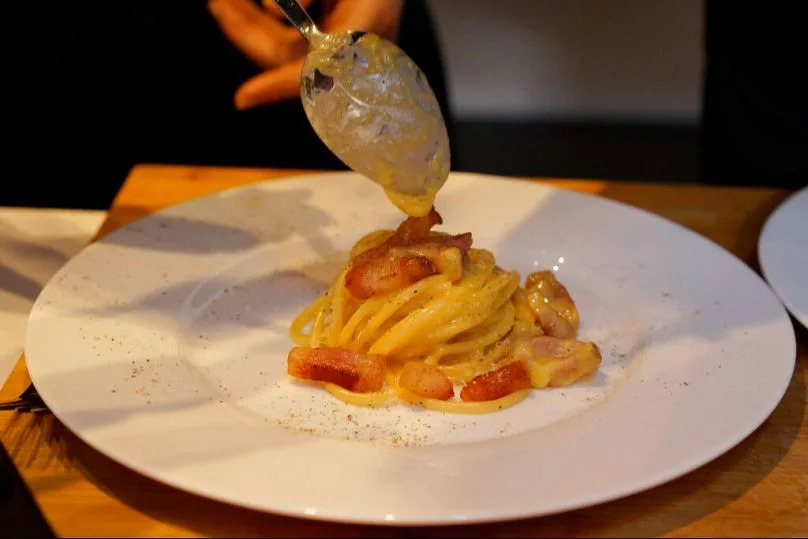 File: One of Italy's most famous dishes 'spaghetti alla carbonara' being prepared on the eve of Carbonara Day, an event created by the Italian Food Union.