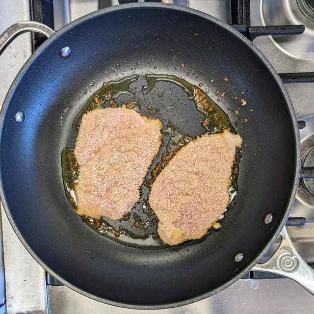 Frying breaded meat in a skillet.