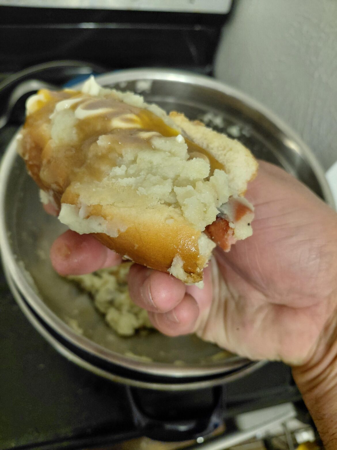 Hot dog with hot sauce mashed potatoes and brown gravy
