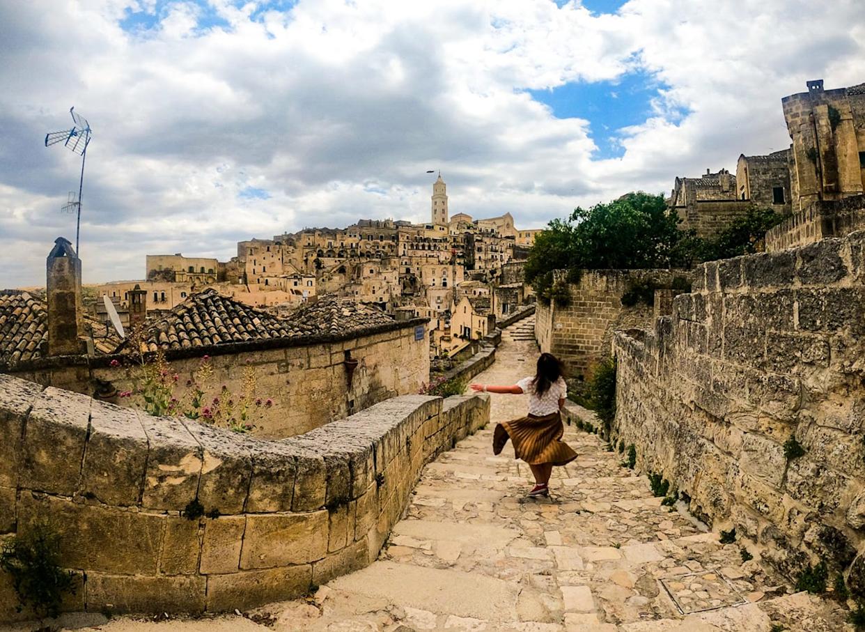 The writer walking down a cobblestone street in Matera, Italy in 2021.