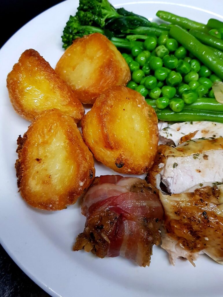 Roast Chicken Crown Stuffed with Garlic Rosemary Butter, Goose Fat Welsh Potatoes, Green Beans, Peas and Brocolli. Stuffing Parcel and White Wine Gravy.