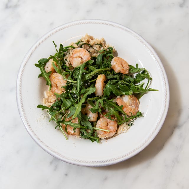 Shrimp and arugula risotto served in a bowl.