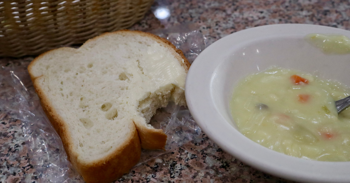 White bread with butter next to a bowl of cream of potato all you can eat soup Michigan.