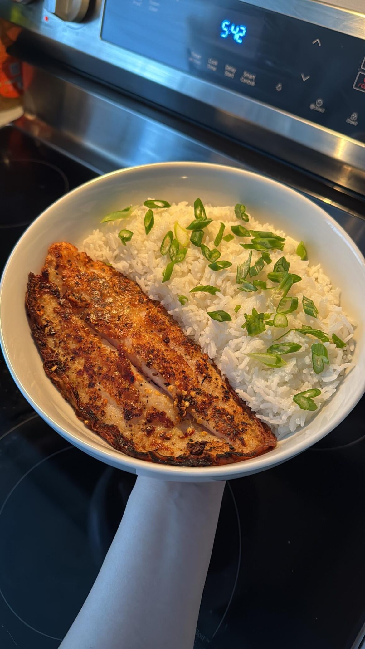 Pan-fried basa fish fillet with rice and green onions