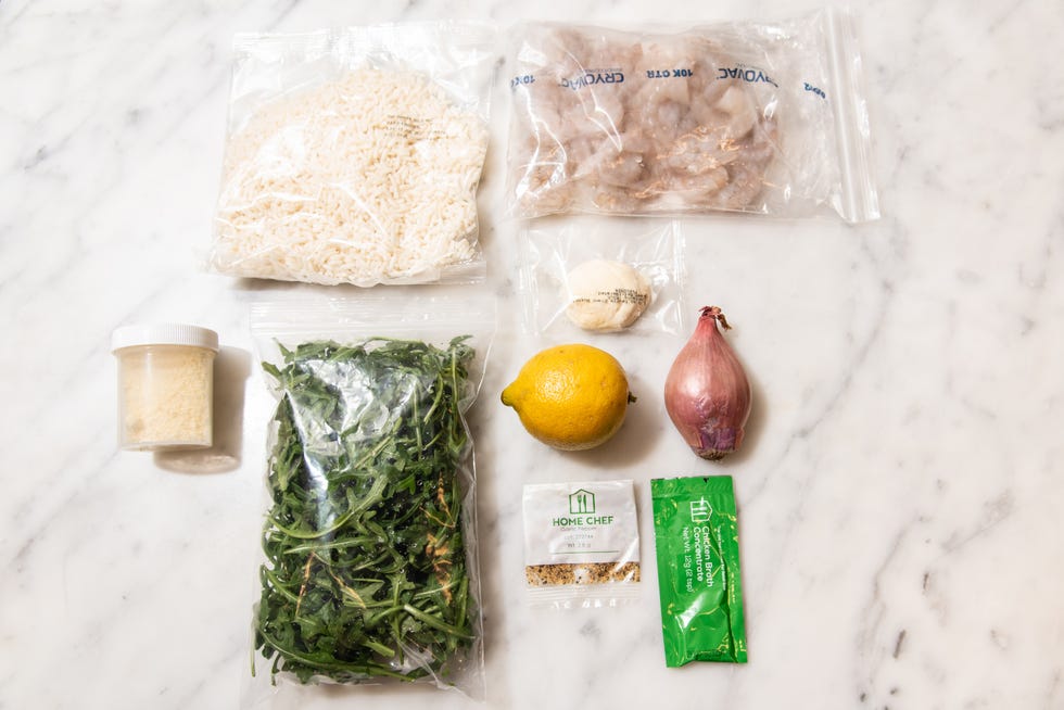 rice, shrimp, arugula, lemon, shallot, and other ingredients for a meal preparation.