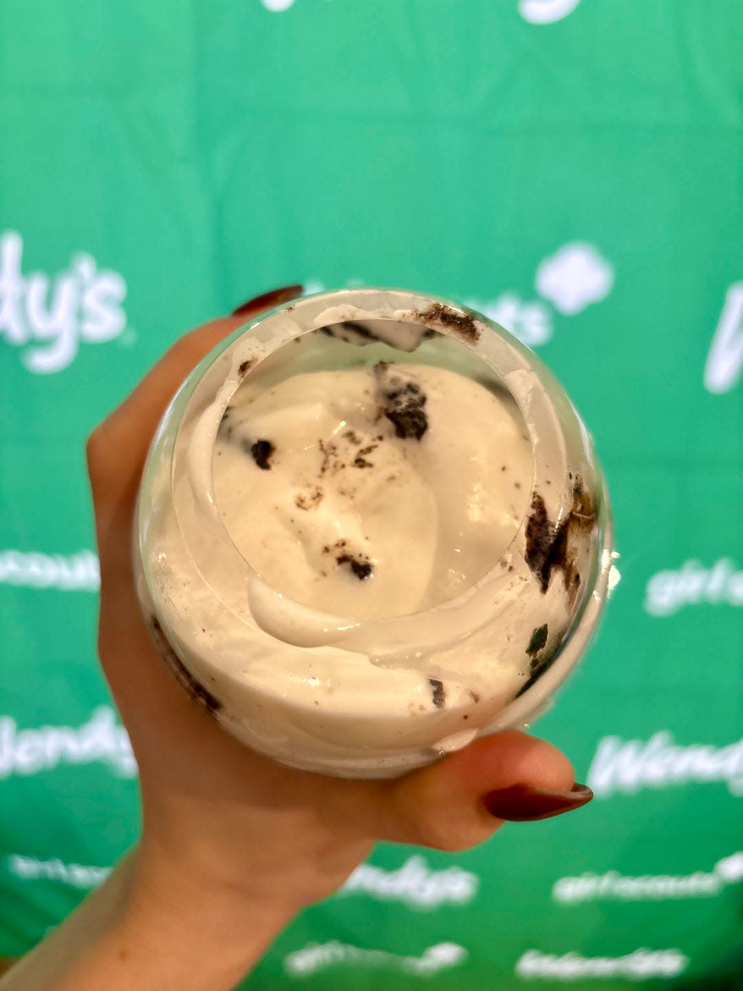 frosty dessert with cookie pieces held in one hand