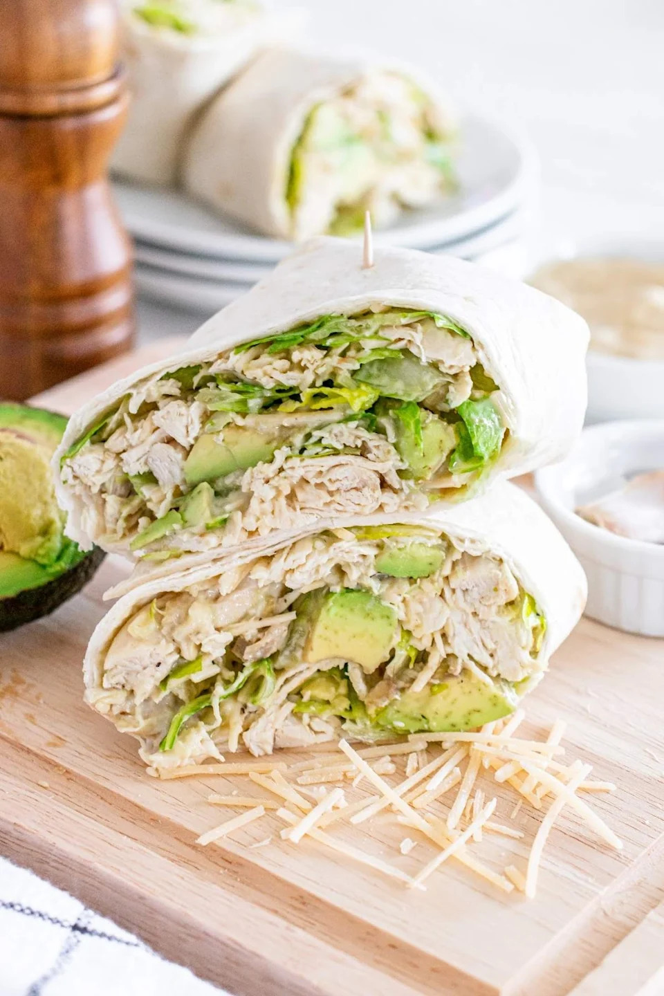 Chicken Caesar avocado wrap sliced in half, revealing the contents.