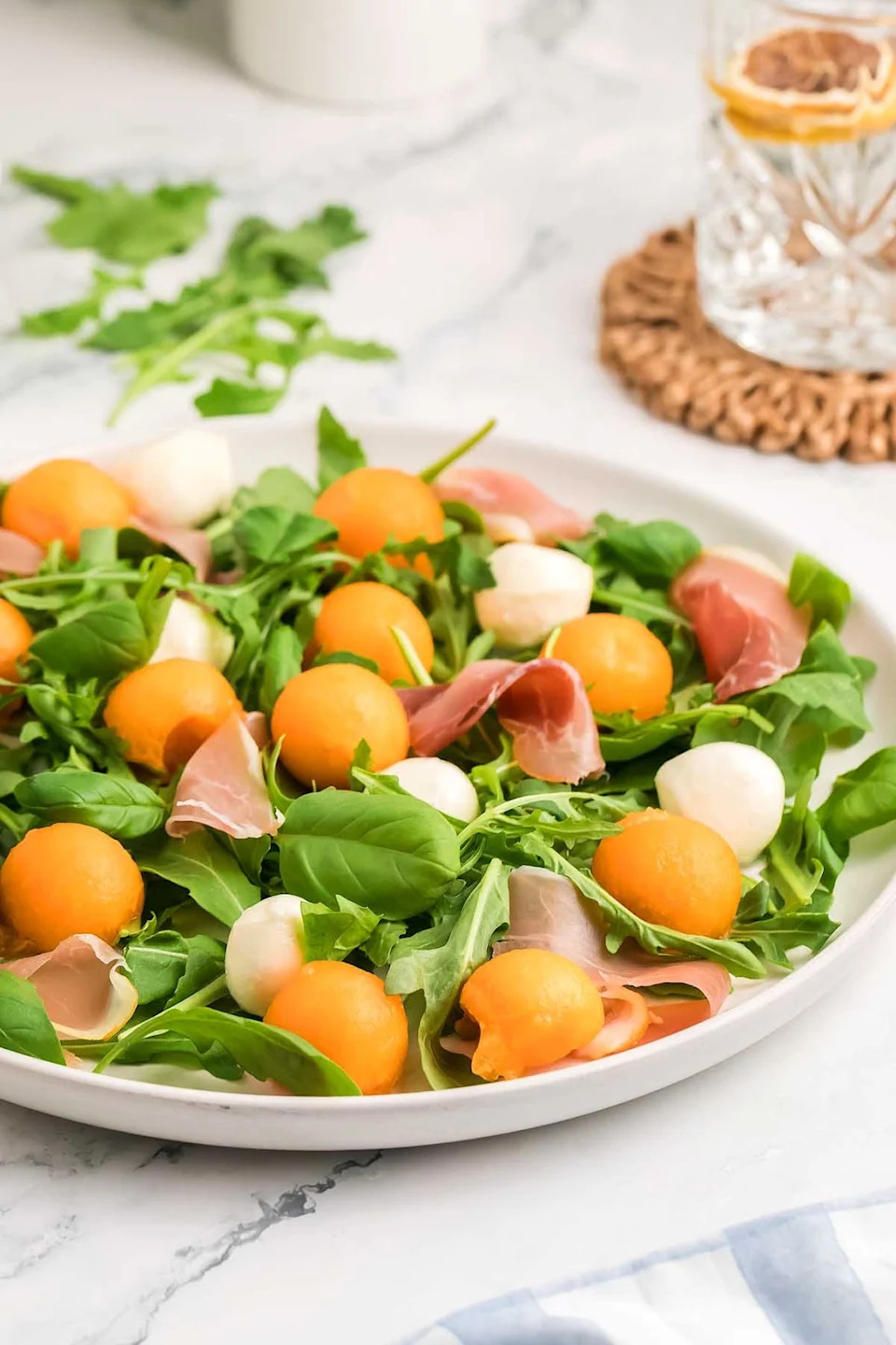Melon prosciutto salad on a white plate.
