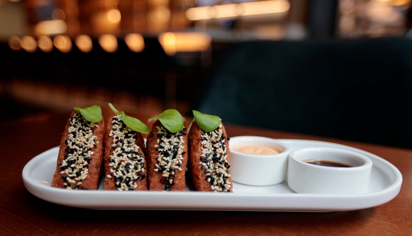 Prawn toast, edged with white and black sesame seeds, is one of the sassy snacks on the menu.