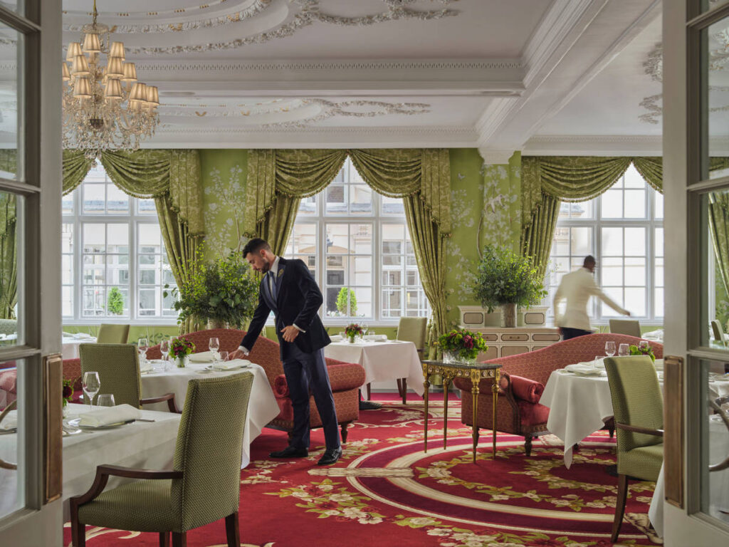 staff putting the finishing touches to tables in the ornate Dining Room at The Goring