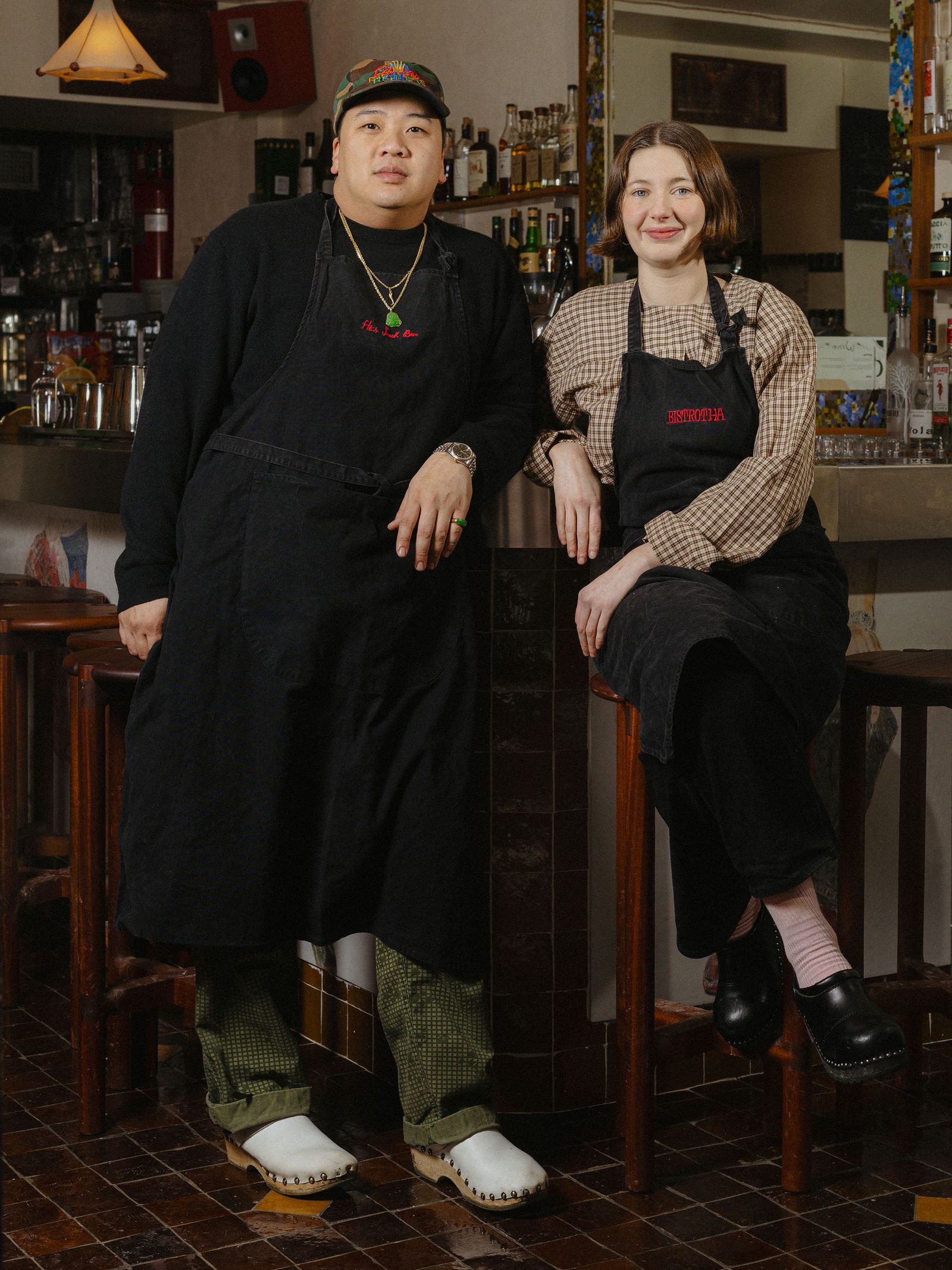 Anthony Ha and Sadie Mae Burns posing by a bar.