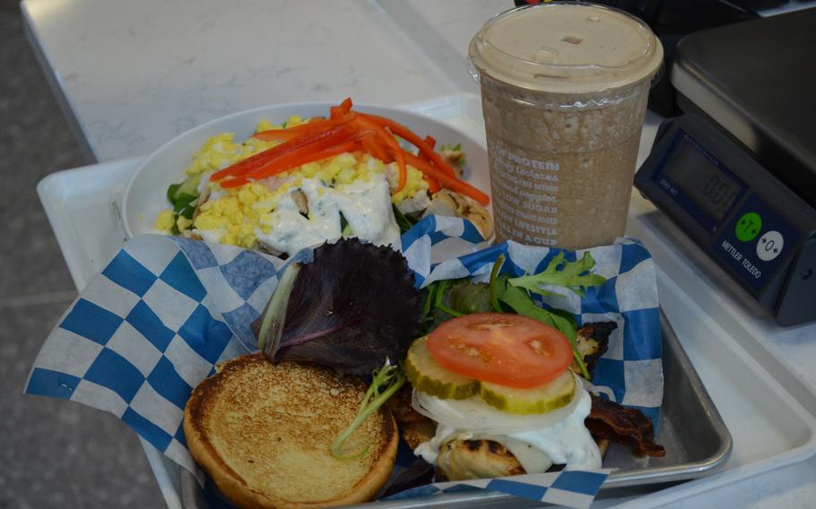 Burger, sandwich and smoothie on the tray.
