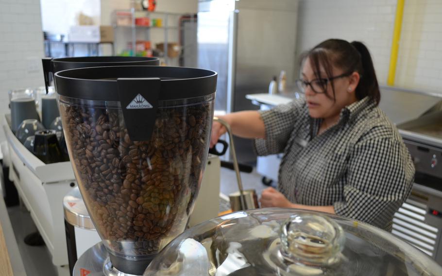 A cannister of coffee beans is in front of Gonzalez as she makes the specialized coffee drink.
