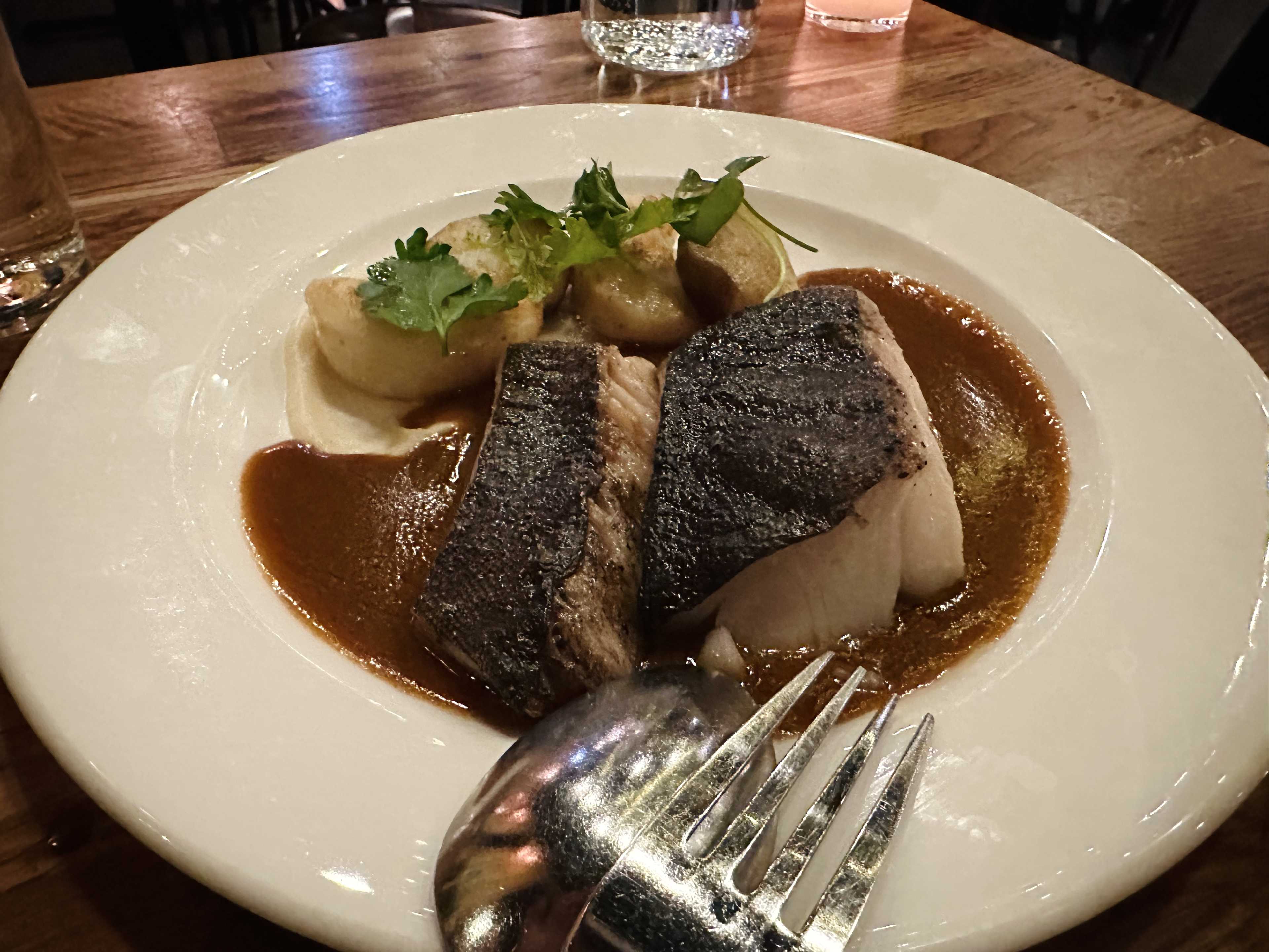 a piece of fish on top of a sauce