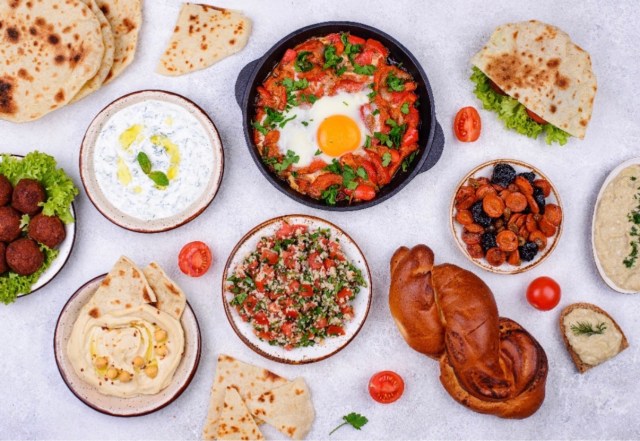 Overhead spread of Middle Eastern dishes including shakshuka, hummus, falafel, flatbreads, tabbouleh, and fresh dips — a vibrant feast reflecting the best hidden restaurants in London locals swear by.